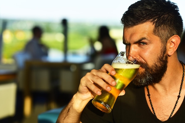 Il ritratto di un bel giovane che assaggia un pub di birra alla spina è un luogo rilassante dove bere e rilassarsi c...