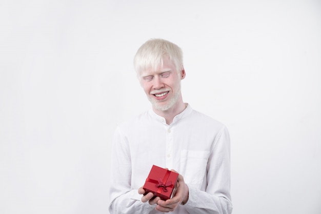 Il ritratto di un uomo dell'albino in studio ha vestito la maglietta isolata su una priorità bassa bianca. deviazioni anormali. aspetto insolito. anomalia della pelle