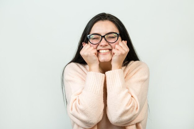 Il ritratto di una bella ragazza con un maglione rosa guarda da parte con un'espressione pensierosa sta valutando un piano per ulteriori azioni