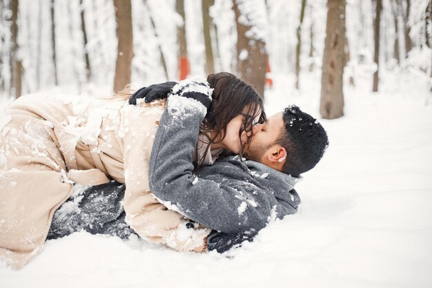 Il ritratto di una coppia romantica giaceva nella neve nella foresta d'inverno