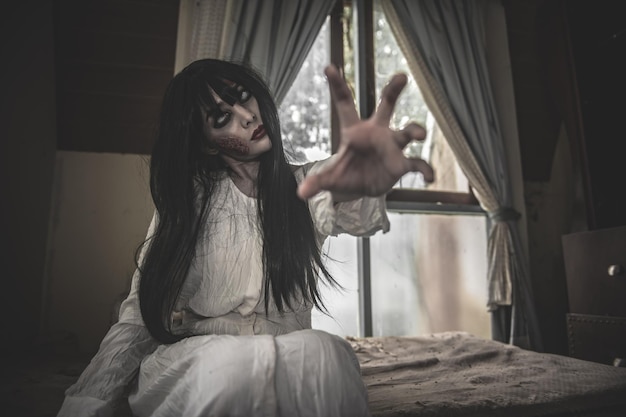 Il ritratto di una donna asiatica compone il fantasmaScena horror spaventosa per lo sfondoConcetto del festival di HalloweenPoster di film fantasma