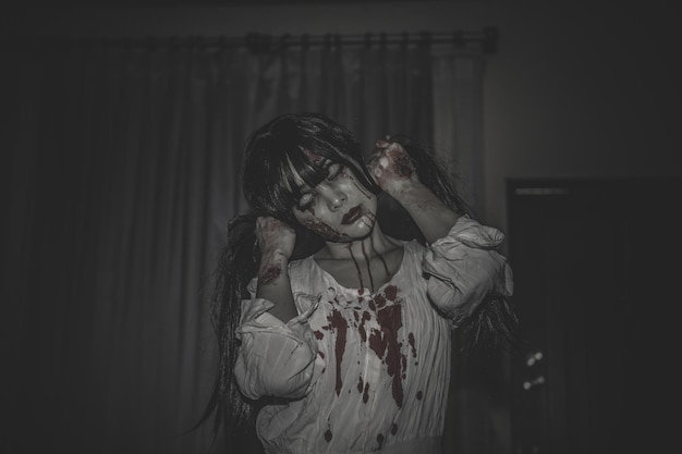Il ritratto di una donna asiatica compone il fantasmaScena horror spaventosa per lo sfondoConcetto del festival di HalloweenPoster di film fantasma