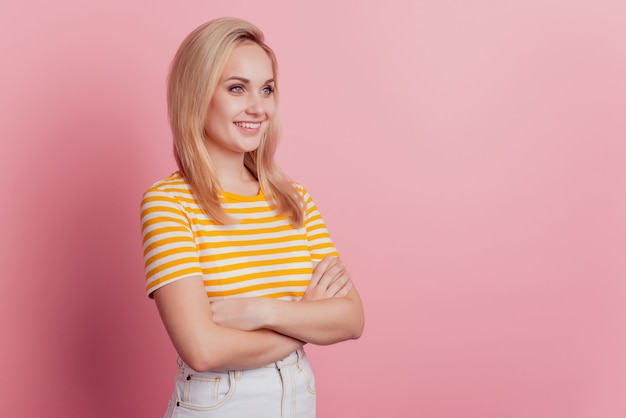 Il ritratto di una donna sicura di sé ha le mani incrociate, il sorriso brillante sembra uno spazio vuoto su sfondo rosa