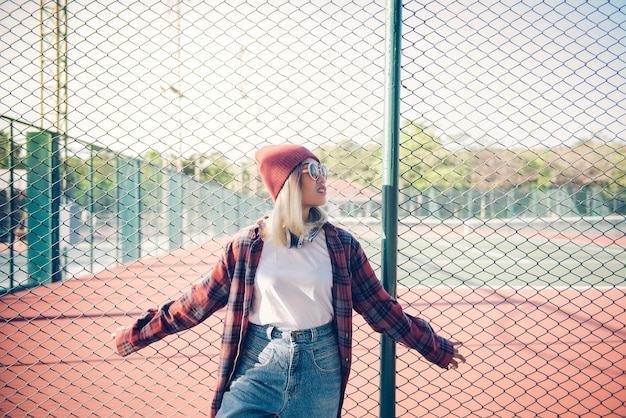 Il ritratto di una ragazza asiatica hipster indossa occhiali da sole arancioni in stile vintage. Persone della Thailandia. Stile di vita della signora moderna