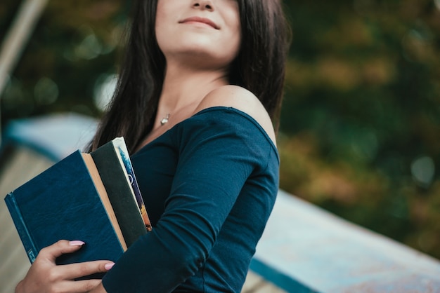 Il ritratto di una studentessa di college sorridente sta tenendo il libro