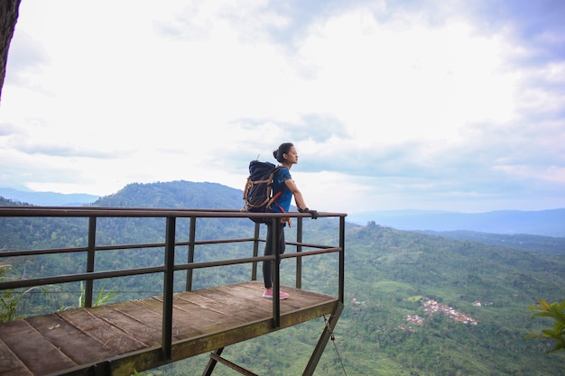 Il riuscito escursionista asiatico della donna gode della vista sulla cima della montagna