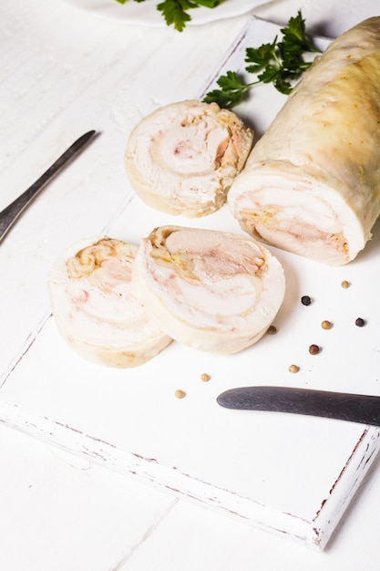 Il rotolo di pollo al forno sul tagliere bianco