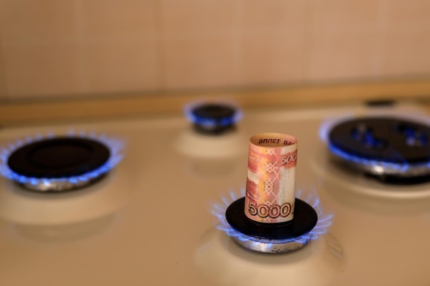 Il rublo russo sta bruciando nel concetto di fuoco l'aumento del prezzo del gas in Russia una bolletta di 5000 rubli brucia in un incendio su una stufa a gas Fornitura di gas costosa