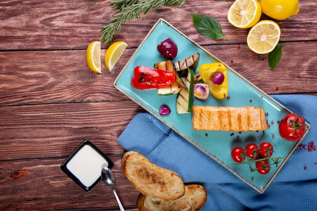 Il salmone arrostito è servito con le verdure arrostite - vista superiore