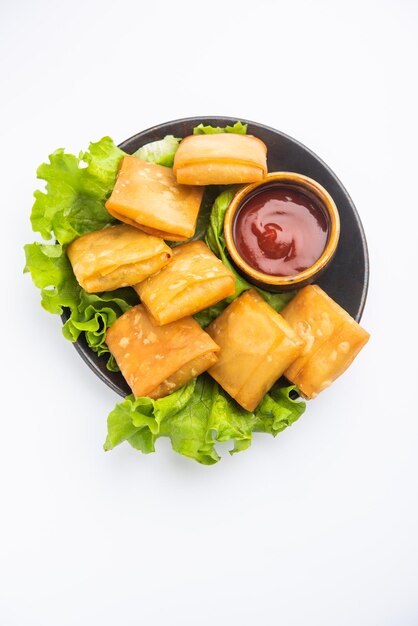 Il samosa cinese di verdure è uno spuntino fritto di forma quadrata preparato con sfoglie di pasta fatta in casa e gustosi ripieni di tagliatelle