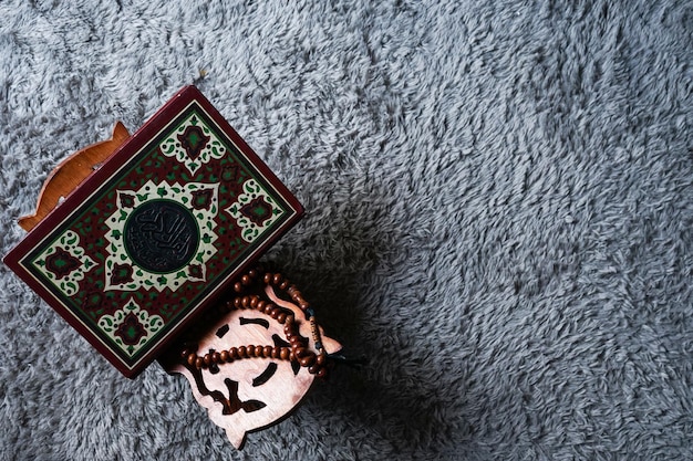 Il Santo Al Quran con calligrafia araba scritta. Al Quran e perline del rosario o tasbih