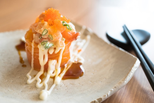 Il sashimi di salmone rotola con crema e uova di pesce volante