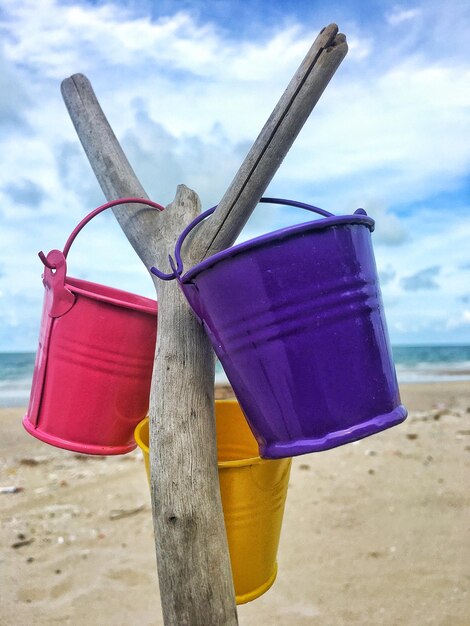 Il secchio era appeso a un ramo asciutto dietro la spiaggia e il mare il cielo era blu scuro con le nuvole