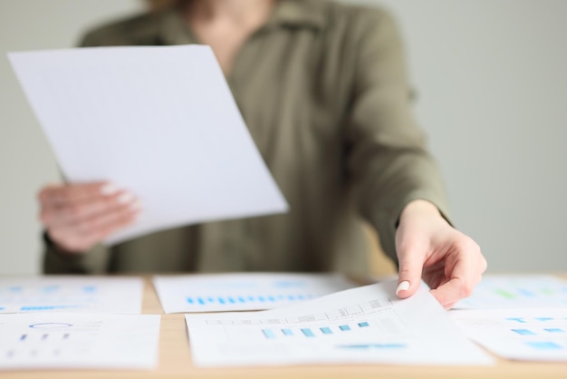 Il segretario ordina i documenti di indagine sul posto di lavoro in ufficio la donna si siede al tavolo di legno che tiene