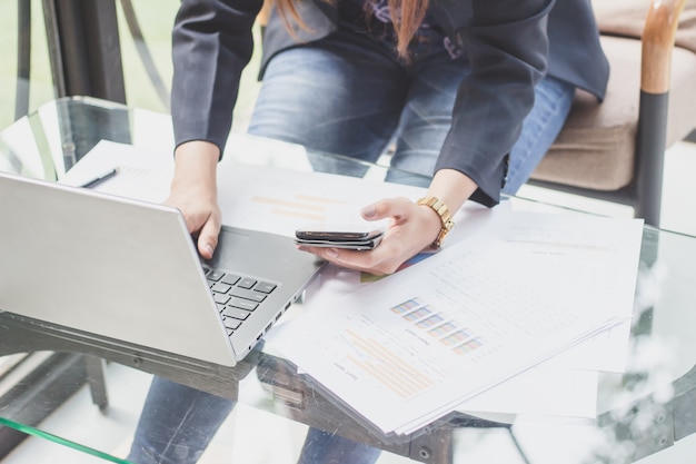 Il segretario prende appunti dal telefono, le giovani donne lavorano su telefoni e quaderni.