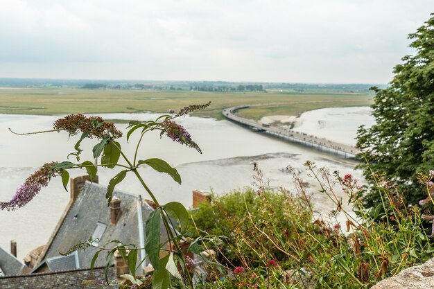 Il sentiero di arrivo alla famosa Abbazia di Mont Saint-Michel con l'alta marea nel dipartimento della Manica, regione della Normandia, France