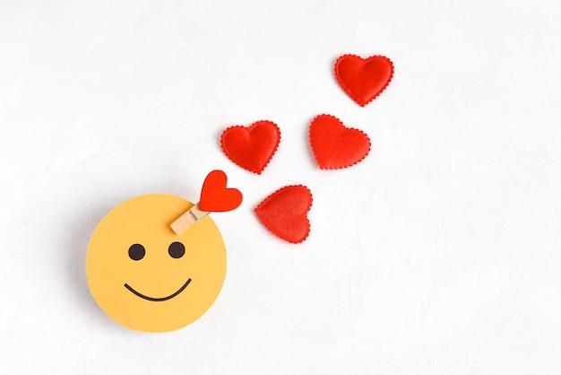 Il simbolo di una persona felice è una faccia rotonda con un cuore su uno sfondo bianco