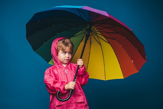 Il simpatico bambino si sta preparando per l'autunno Saldi per l'intera collezione autunnale sconti incredibili e meravigliosa scelta Ragazzo allegro in impermeabile con ombrello colorato Bambino sotto la pioggia