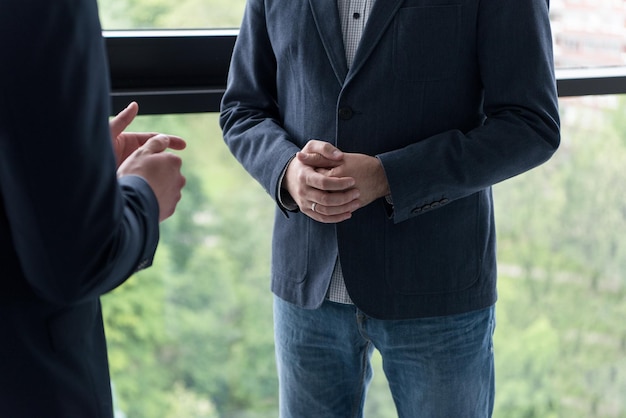 Il socio commerciale agita le mani sul meetinig nell&#39;edificio per uffici moderno