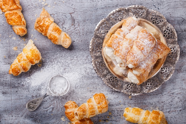 Il soffio rotola con crema sul piatto di metallo d&#39;annata.