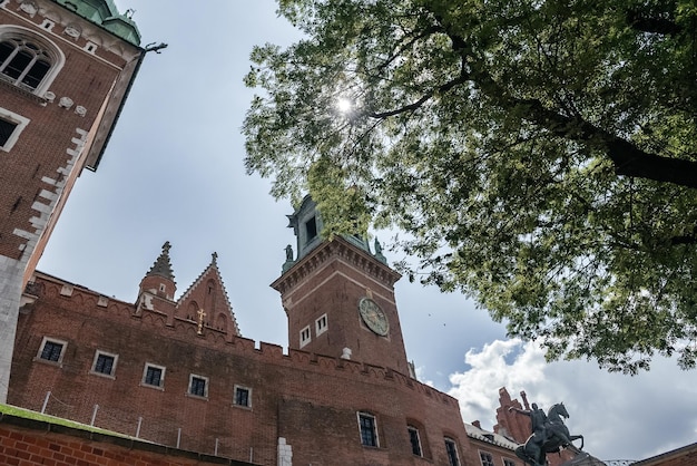 Il sole attraverso le foglie sopra i castelli wawel l'iconica torre dell'orologio