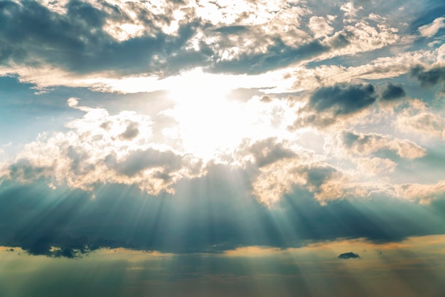 Il sole che attraversa le nuvole con i raggi in un cielo cupo Cambiamento del tempo in mare Sfondo del primo piano Spazio per il testo