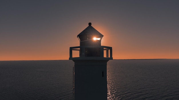 Il sole splende sulla torre del faro di navigazione marittima