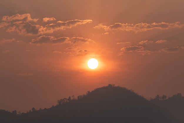 Il sole sul cielo arancione al mattino e la vista sulle montagne