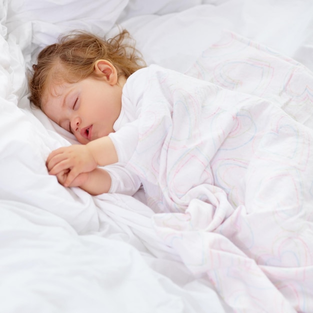 Il sonno è importante per lo sviluppo Un bambino carino che dorme sul letto