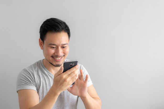 Il sorriso e la faccia felice dell&#39;uomo usano e toccano il suo smartphone.