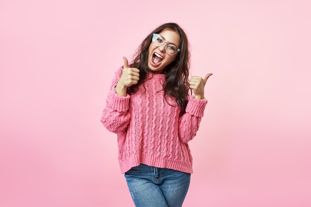 Il sorriso emozionante felice della donna che tiene i pollici aumenta il gesto