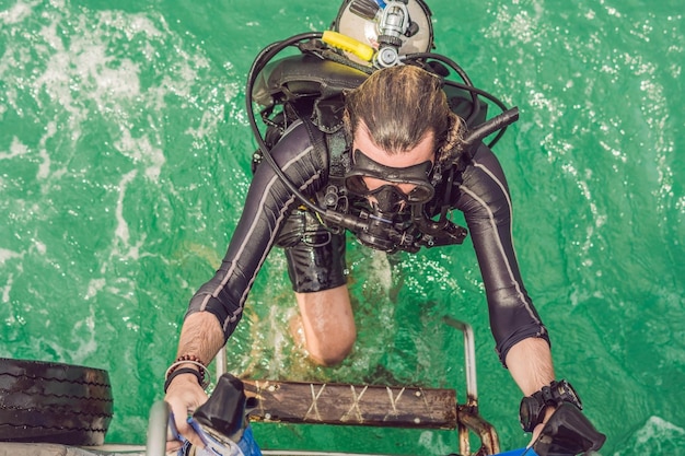 Il subacqueo felice torna alla nave dopo l'immersione