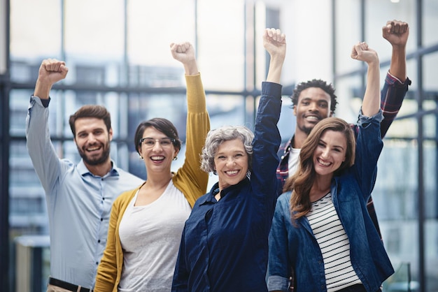 Il successo deve essere celebrato Ritratto ritagliato di un gruppo di uomini d'affari che celebrano il loro successo