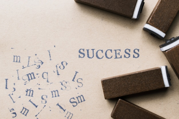 Il successo di parola della lettera dell&#39;alfabeto dal bollo segna la fonte con lettere su carta per il fondo di concetto di successo