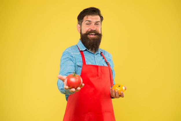 Il succo di pomodoro è una bevanda popolare cibo sano e biologico dieta vegetariana piena di vitamine naturali brutale cuoco in grembiule gestione del diabete uomo barbuto chef beve succo di pomodoro