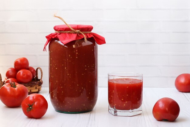 Il succo di pomodoro in lattina e in un bicchiere è sul tavolo