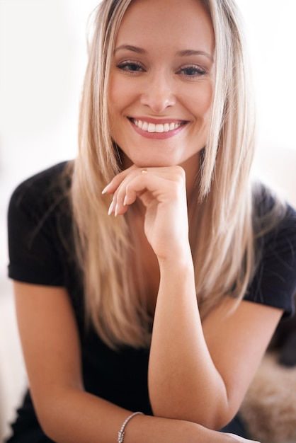 Il suo sorriso mette tutti a proprio agio Ritratto di una giovane donna seduta con la mano sul mento