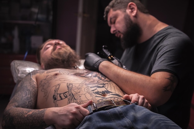 Il tatuatore professionista disegna un tatuaggio