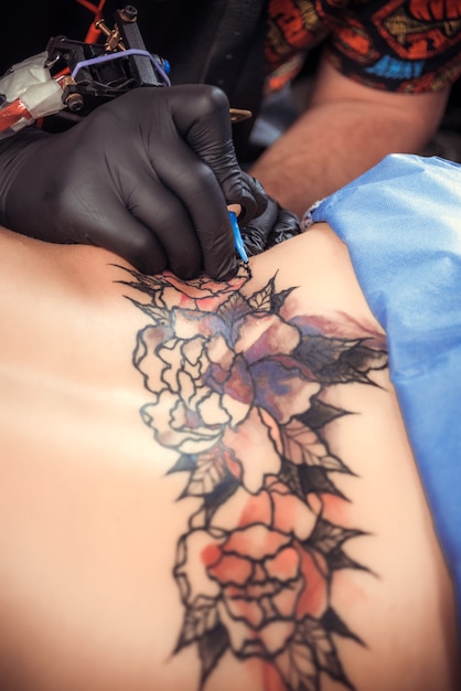 Il tatuatore professionista fa un bel tatuaggio nel salone di tatuaggi