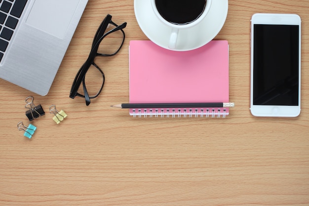 Il tavolo da lavoro in legno ha un computer e una tazza da caffè.