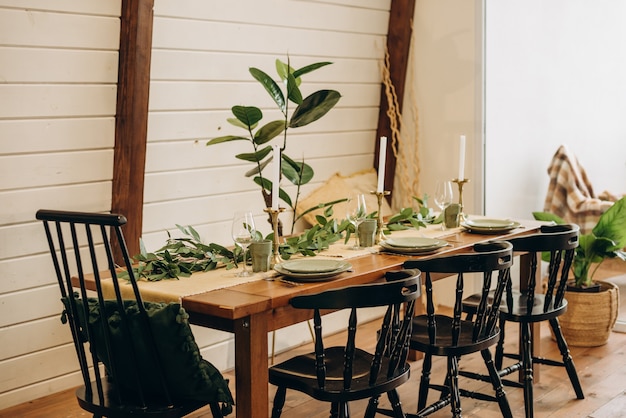 Il tavolo da pranzo loft è decorato con fiori, candele ed erbe aromatiche