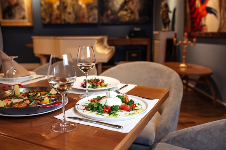 Foto il tavolo del ristorante è servito con paella e insalate di pomodoro e peperoni buratta spagnola