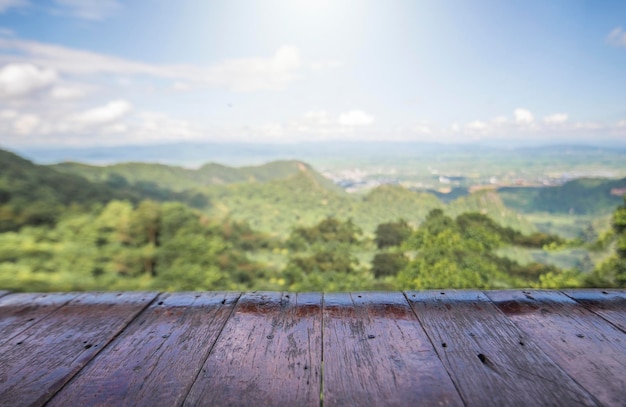 Il tavolo in legno e la bellezza sfocano il cielo e le montagne come sfondo