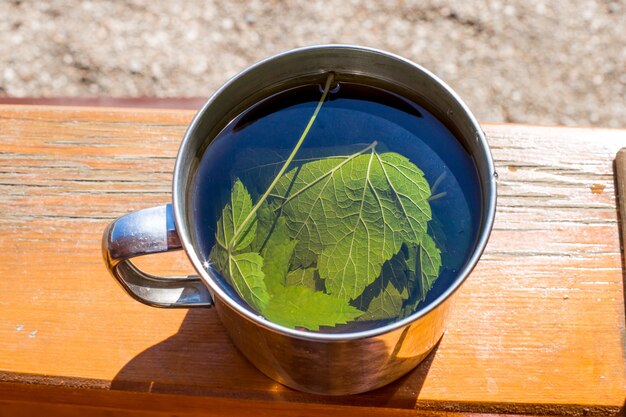 Il tè con foglie di ribes viene preparato in una tazza di metallo.