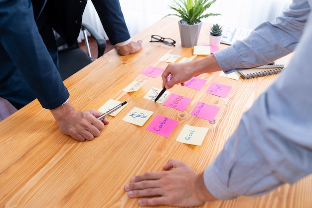 Il team aziendale si riunisce sul tavolo per il brainstorming e la scrittura di un'idea creativa fervente