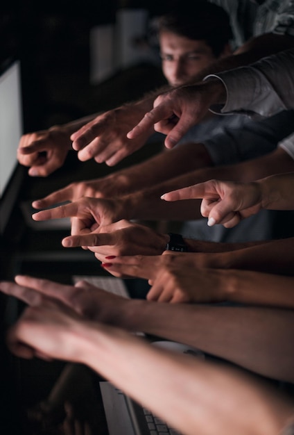 Il team di affari che punta il dito sulla foto vuota dello schermo del computer con lo spazio della copia