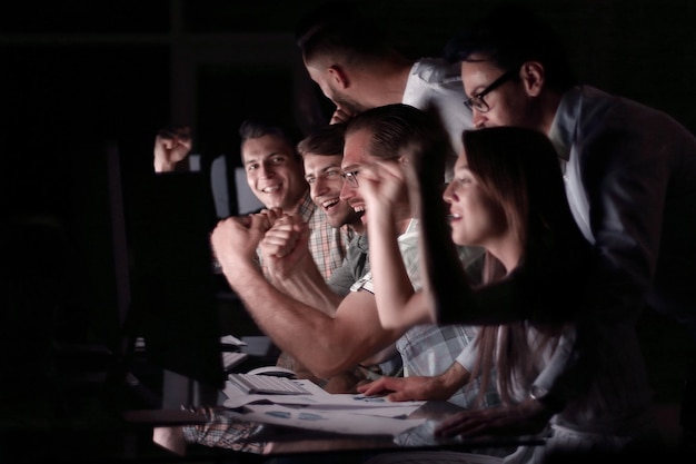 Il team di affari sorride guardando il monitor del computer