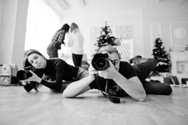 Il team di due fotografi è sdraiato sul pavimento e riprende in studio