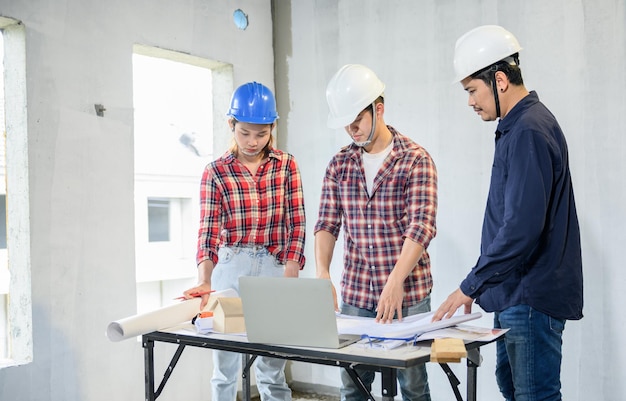 Il team di ingegneri discute e lavora in un cantiere edile. Ispezione al progetto del villaggio e alla costruzione della proprietà.