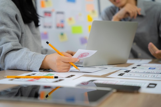 Il team di sviluppatori dell'agenzia di sviluppo digitale creativo fa il brainstorming sul proprio progetto con laptop e tablet digitale